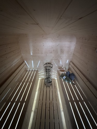 Innenraum der SpaDucha Qubik Lux Sauna – Harvia Ofen, LED-Beleuchtung, doppelte Sitzbänke.