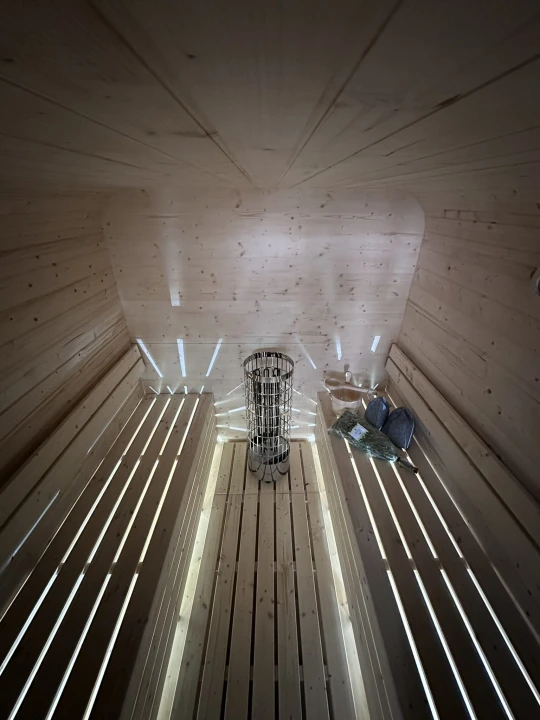 Innenraum der SpaDucha Qubik Lux Sauna – Harvia Ofen, LED-Beleuchtung, doppelte Sitzbänke.