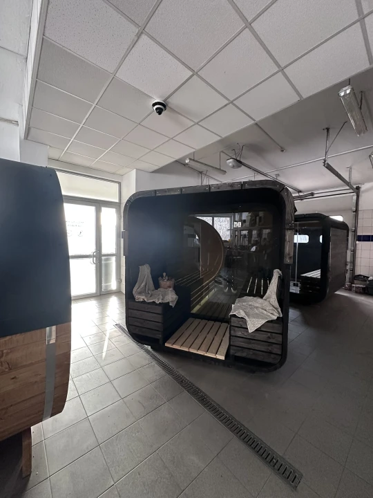 Terrasse der Qubik Lux Außensauna – Sitzbänke, skandinavisches Design, Holzveredelung.